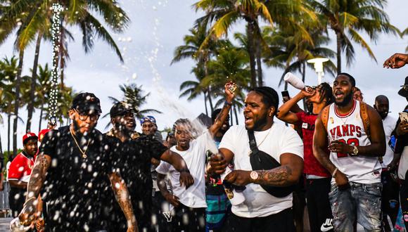 La gente rocía alcohol y baila en Ocean Drive entes del toque de queda en Miami Beach, Florida, el 27 de marzo de 2021, en plena pandemia de coronavirus en Estados Unidos. (Foto de CHANDAN KHANNA / AFP).