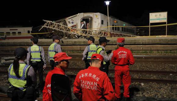 Funcionarios del equipo de búsqueda y rescate de Taiwan esperan que una grúa llegue al lugar del accidente luego de que el tren Puyuma Express se descarrilara. (Foto: AFP)