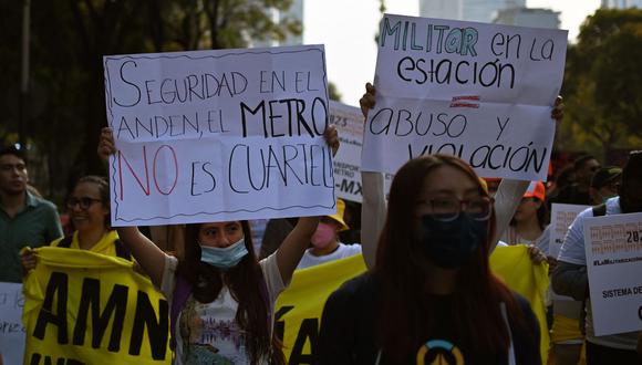 Los manifestantes sostienen carteles durante una protesta contra la presencia de la Guardia Nacional en las estaciones del metro de la Ciudad de México, en la Ciudad de México.