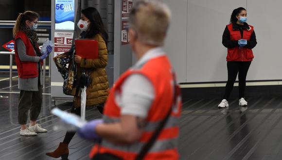 Voluntarios de la Cruz Roja española distribuyen mascarillas en la estación Chamartín de Madrid. (Foto: PIERRE-PHILIPPE MARCOU / AFP)
