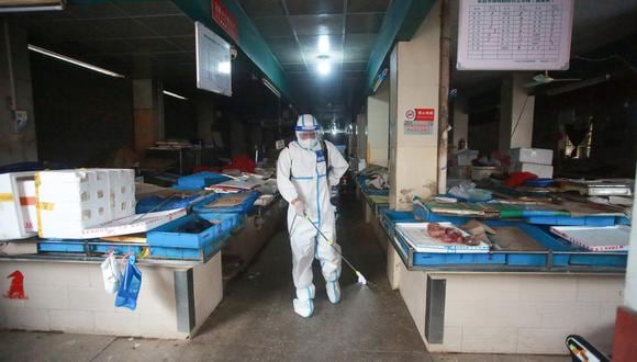 Esta foto tomada el 23 de agosto de 2021 muestra a un bombero rociando desinfectante en un mercado en Yangzhou, en la provincia de Jiangsu, en el este de China. (Foto: STR / AFP)