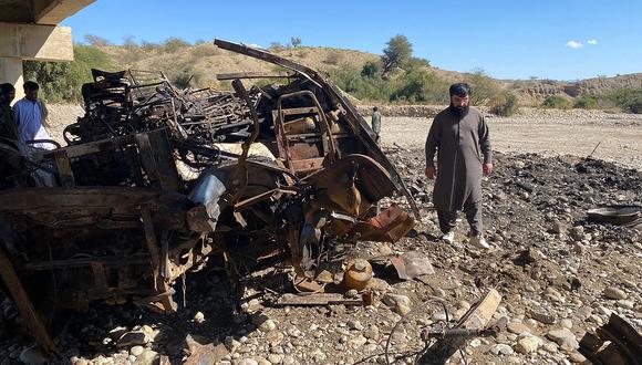 Los residentes observan los restos de un autobús de pasajeros quemado en Bela, en el distrito de Lasbela de la provincia pakistaní de Baluchistán, el 29 de enero de 2023. (Foto de Ismail Sasoli / AFP)