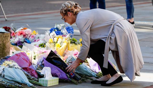 People lay down flowers ahead of a vigil in Albert Square, Manchester, England, Tuesday May 23, 2017, the day after the suicide attack at an Ariana Grande concert that left 22 people dead as it ended on Monday night. (AP Photo/Kirsty Wigglesworth)
