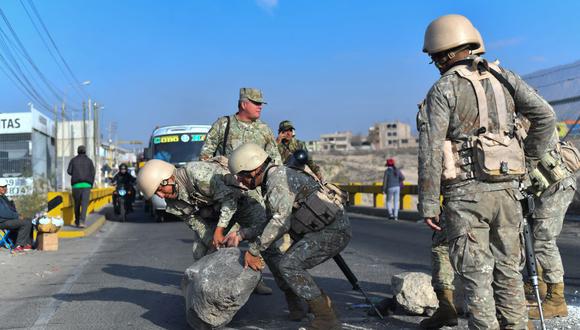 Soldados limpian los escombros dejados por los alborotadores de la Carretera Arequipa-Puno en el Puente Añashuayco, el 15 de diciembre de 2022. (DIEGO RAMOS / AFP).