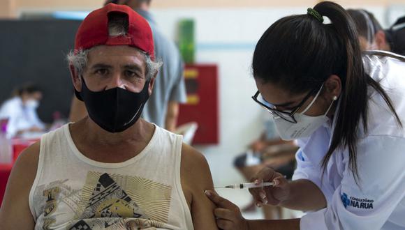 Una personas es inoculada con la vacuna CoronaVac contra el COVID-19 durante una campaña de inmunización en las calles de Sao Paulo, Brasil, el 30 de marzo de 2021. (Miguel SCHINCARIOL / AFP).