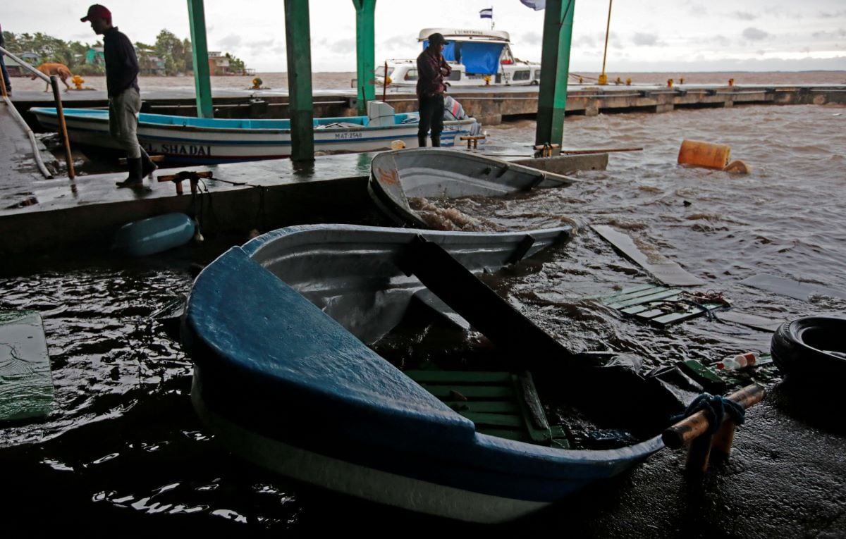 Fishermen look at their sunken boats after Hurricane Julia hit the town of Bluefields, on Nicaragua's Caribbean coast.  (OSWALDO RIVAS / AFP).