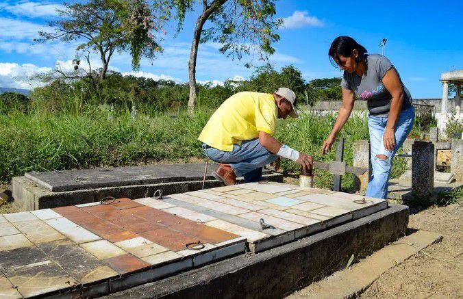 Winder Campos (left) and Solidett Campos visit the grave of their brother Manuel Campos, one of the nine people who died after drinking adulterated alcohol, in the Chivacoa community cemetery, Yaracuy state, Venezuela.