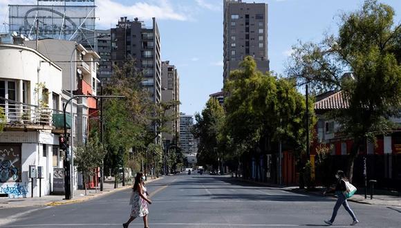 Dos mujeres caminan por una avenida semi vacía en Santiago de Chile. La ciudad se encuentra en una nueva jornada de cuarentena obligatoria decretada ante el avance del coronavirus. (EFE/ Alberto Valdés).