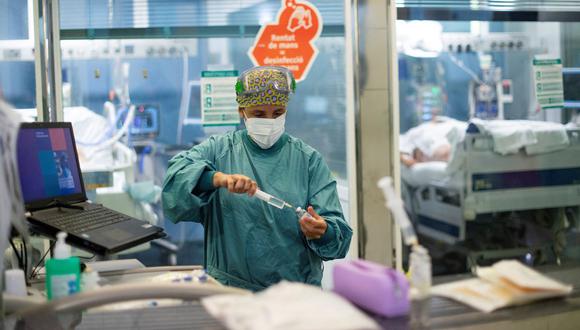 Una trabajadora sanitaria prepara una inyección mientras atiende a un paciente de coronavirus en la Unidad de Cuidados Intensivos (UCI) del Hospital del Mar de Barcelona, España, el 4 de agosto de 2021. (Josep LAGO / AFP).