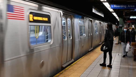 Las personas viajan a través de una estación de metro en la ciudad de Nueva York el 13 de abril de 2022, un día después de que las personas resultaran heridas durante un tiroteo en la hora pico en el distrito de Brooklyn de Nueva York.  (Foto de Ángela Weiss / AFP).