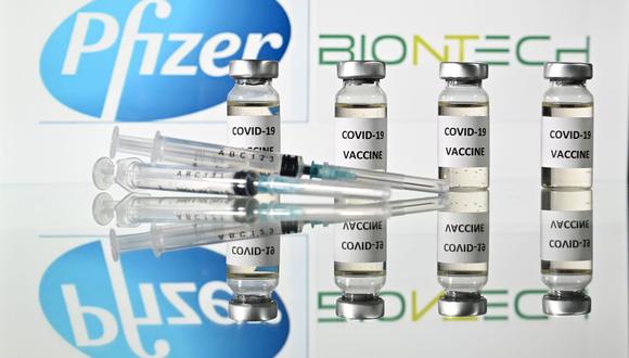 En esta foto de archivo tomada el 17 de noviembre de 2020 se muestra viales con adhesivos de la vacuna COVID-19 adheridos y jeringas con el logotipo de la compañía farmacéutica estadounidense Pfizer y el socio alemán BioNTech. (Foto de JUSTIN TALLIS / AFP).