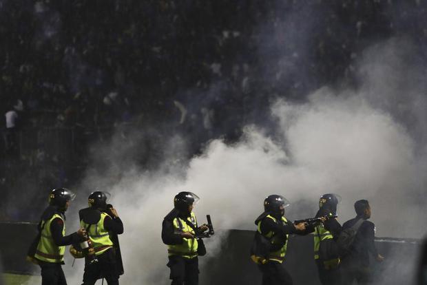 La policía lanza gases lacrimógenos durante un partido de fútbol en el estadio Kanjuruhan en Malang, Java Oriental, Indonesia, el sábado 1 de octubre de 2022. (Foto AP/Yudha Prabowo).