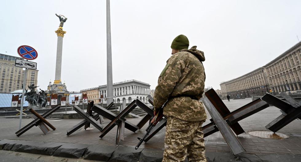 Un combatiente de las Fuerzas de Defensa Territorial de Ucrania, la reserva militar de las Fuerzas Armadas, hace guardia junto a barreras antitanques en la Plaza de la Independencia en Kiev el 2 de marzo de 2022. (SERGEI SUPINSKY / AFP).