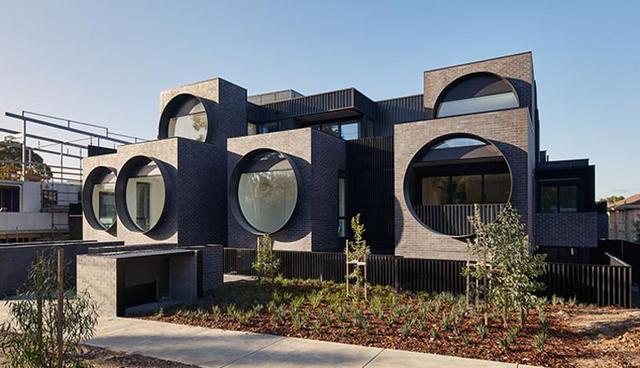 Esta es la fachada de un complejo residencial ubicado en la ciudad de Melbourne, Australia.  De acuerdo a los arquitectos del proyecto, las grandes cajas de ladrillos en tonos oscuros se proyectan a diversas profundidades, reproduciendo el ritmo de un paisaje suburbano. (Foto: BKK Architects)
