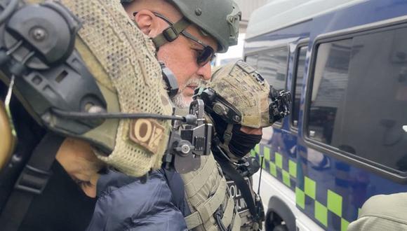 El exjefe paramilitar colombo-italiano Salvatore Mancuso es escoltado por miembros de la Policía Nacional a su llegada al Aeropuerto Internacional El Dorado de Bogotá el 27 de febrero de 2024. (Foto de Handout / Interpol Colombia / AFP)