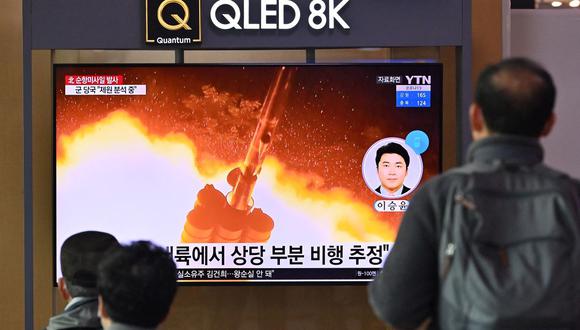 La gente mira una pantalla de televisión que muestra una transmisión de noticias con imágenes de archivo de una prueba de misiles de Corea del Norte, en una estación de tren en Seúl el 25 de enero de 2022. (Jung Yeon-je / AFP).