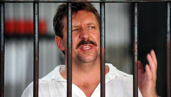 En esta foto de archivo, el traficante de armas ruso Viktor Bout habla con la prensa desde detrás de las rejas de su celda del centro de detención del tribunal penal en Bangkok. (Foto de Saeed KHAN / AFP)