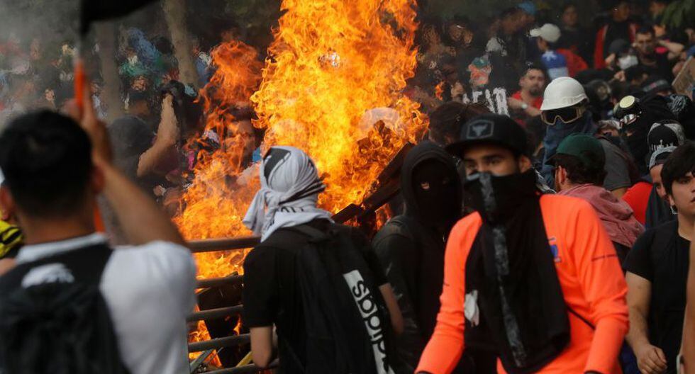 Demonstrators gather in front of a subway entrance blocked by burning debris during a protest against Chile's state economic model in Santiago, Chile October 25, 2019. REUTERS/Henry Romero