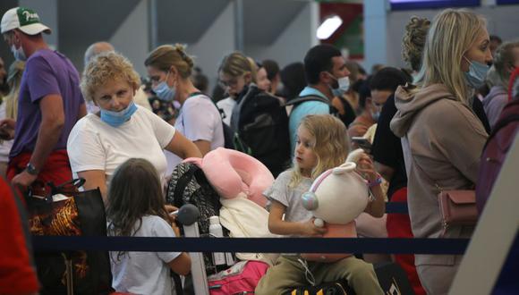 Turistas de origen ruso a la espera de abordar un avión de regreso a su país de origen hoy, en el aeropuerto internacional del balneario de Cancún, estado de Quintana Roo (México). (Foto: EFE/Lourdes Cruz).