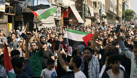 La gente ondea la bandera palestina durante una protesta en apoyo al pueblo palestino después de las oraciones del mediodía del viernes frente a la mezquita de al-Azhar en El Cairo el 20 de octubre de 2023, en medio de las batallas en curso entre Israel y el grupo palestino Hamas. (Foto de Khaled DESOUKI / AFP)