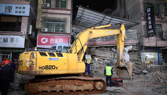 Los rescatistas trabajan junto a una excavadora en un sitio donde se derrumbó un edificio en Changsha, provincia de Hunan, China.