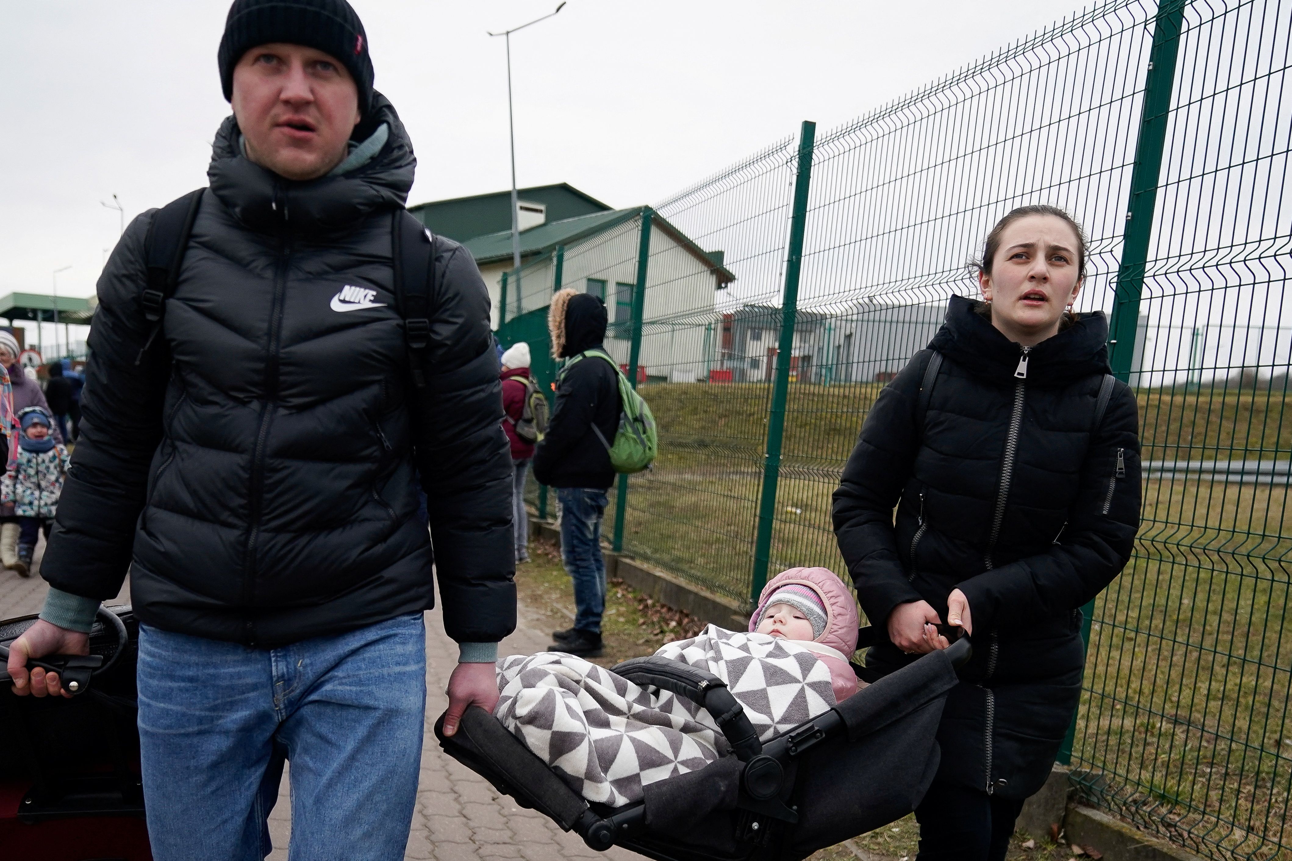 A family leaves the border after crossing to flee violence in Ukraine, in Medyka, Poland.  (REUTERS/Bryan Woolston).