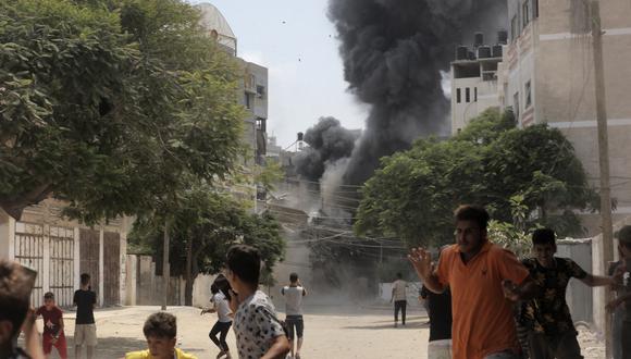 La gente corre para ponerse a cubierto durante el bombardeo aéreo israelí en la ciudad de Gaza el 6 de agosto de 2022. (Foto: ANAS BABA / AFP)