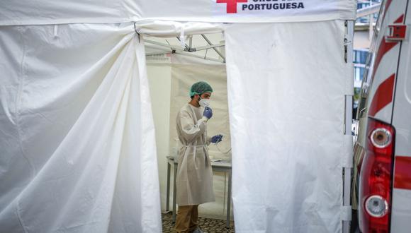 Un trabajador de la salud con traje protector se encuentra en un centro móvil de pruebas de coronavirus de la Cruz Roja instalado en la estación de Oriente en Lisboa el 2 de julio de 2021. (PATRICIA DE MELO MOREIRA / AFP).