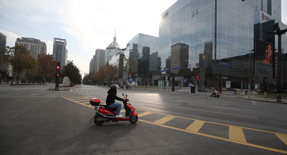Esta foto del 28 de diciembre de 2021 muestra a un hombre conduciendo una scooter un la ciudad de en Xi'an, que está en cuarentena por coronavirus. (STR / AFP).