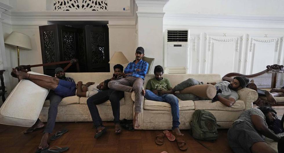 Los manifestantes descansan en los sofás de la sala de estar de la residencia oficial del primer ministro un día después de destrozarla en Colombo, Sri Lanka, el domingo 10 de julio de 2022. (Foto AP/Eranga Jayawardena).