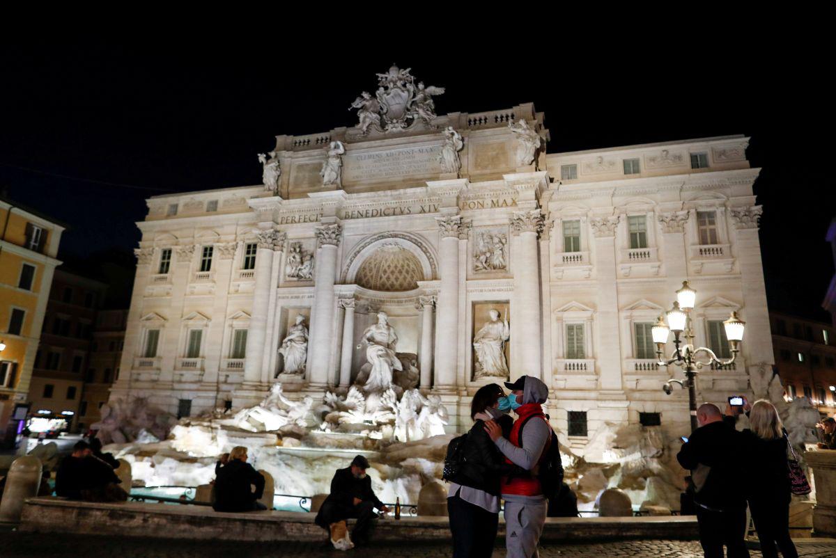 Una pareja se besa provistos de marcarillas frente a una desolada Fontana di Trevi, en Roma, el pasado 10 de marzo. (Foto: REUTERS/Yara Nardi)