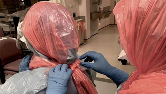 La doctora Roberts ayuda a sus colegas a ponerse bolsas de basura en la cabeza. Foto: BBC Mundo