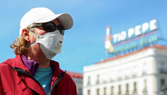 Una mujer usa una mascarilla protectora mientras está parada en uno de los principales puntos de interés turístico en Madrid, la Puerta del Sol. España registra más de 2.000 casos de coronavirus. (REUTERS / Sergio Pérez).