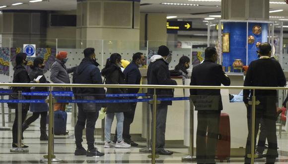Pasajeros hacen cola para llenar los documentos para tomar la prueba coronavirus a su llegada al Aeropuerto Internacional Sri Guru Ram Dass Jee en las afueras de Amritsar, India. (Foto de archivo: Narinder NANU / AFP).
