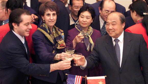 Charlene Barshefsky, Shi Guangsheng, y Gene Sperling, brindan con champán por la firma de acuerdos bilaterales sobre la adhesión de China a la Organización Mundial del Comercio el 15 de noviembre de 1999 en Beijing. (Foto de STEPHEN SHAVER / AFP)