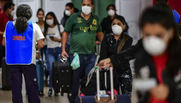 Pasajeros con mascarilla como medida preventiva contra la propagación del coronavirus COVID-19 arriban al Aeropuerto Internacional de Ezeiza en Buenos Aires. (Foto: Ronaldo SCHEMIDT / AFP).