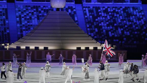 Hannah Mills y Mohamed Sbihi, de Gran Bretaña, portan la bandera de su país durante la ceremonia de inauguración de los Juegos Olímpicos de Tokio 2020 en el estadio olímpico el 23 de julio de 2021 en Tokio, Japón. (Foto AP/Kirsty Wigglesworth)