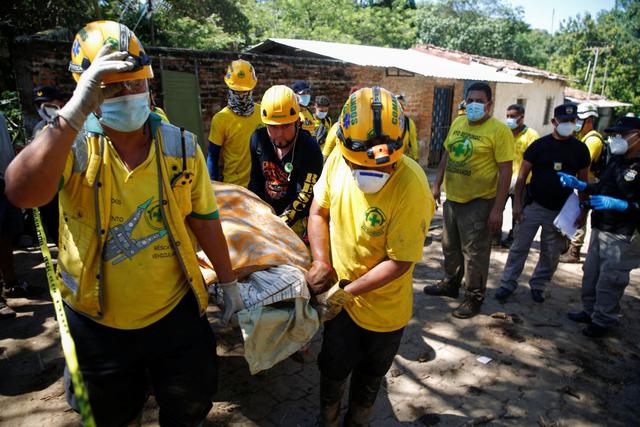 Los socorristas llevan el cuerpo de una víctima de un deslizamiento de tierra en Nejapa, El Salvador. (REUTERS/Jose Cabezas).