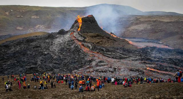 Los excursionistas del domingo observan la lava que fluye del volcán Fagradalsfjall en erupción a unos 40 km al oeste de la capital islandesa, Reykjavik. (Foto: AFP / Jeremie RICHARD).