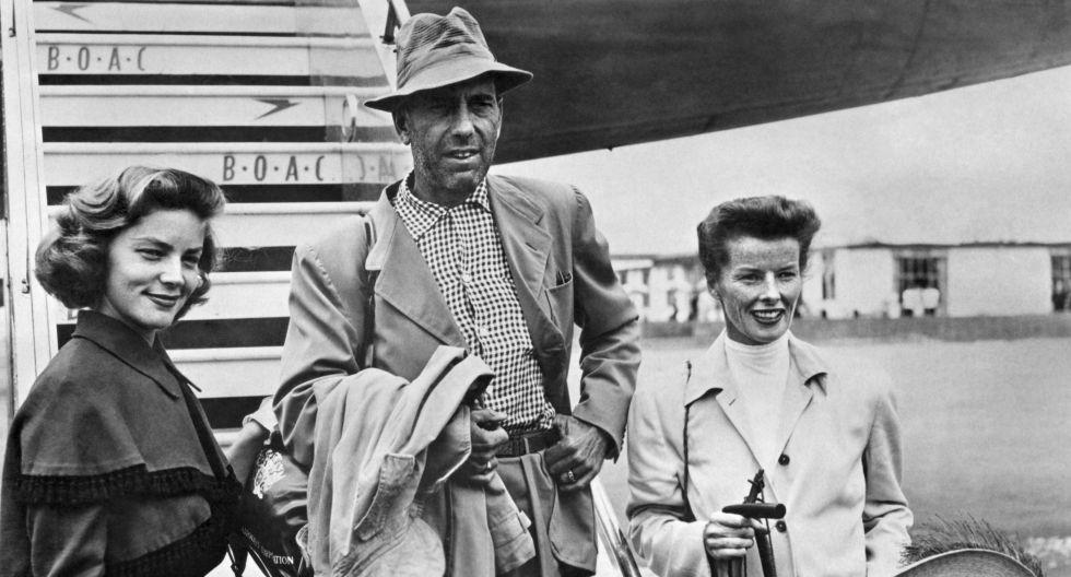 Humphrey Bogart es flanqueado por su esposa Lauren Bacall (izq.) y la actriz Katherine Hepburn. (Foto: AFP)