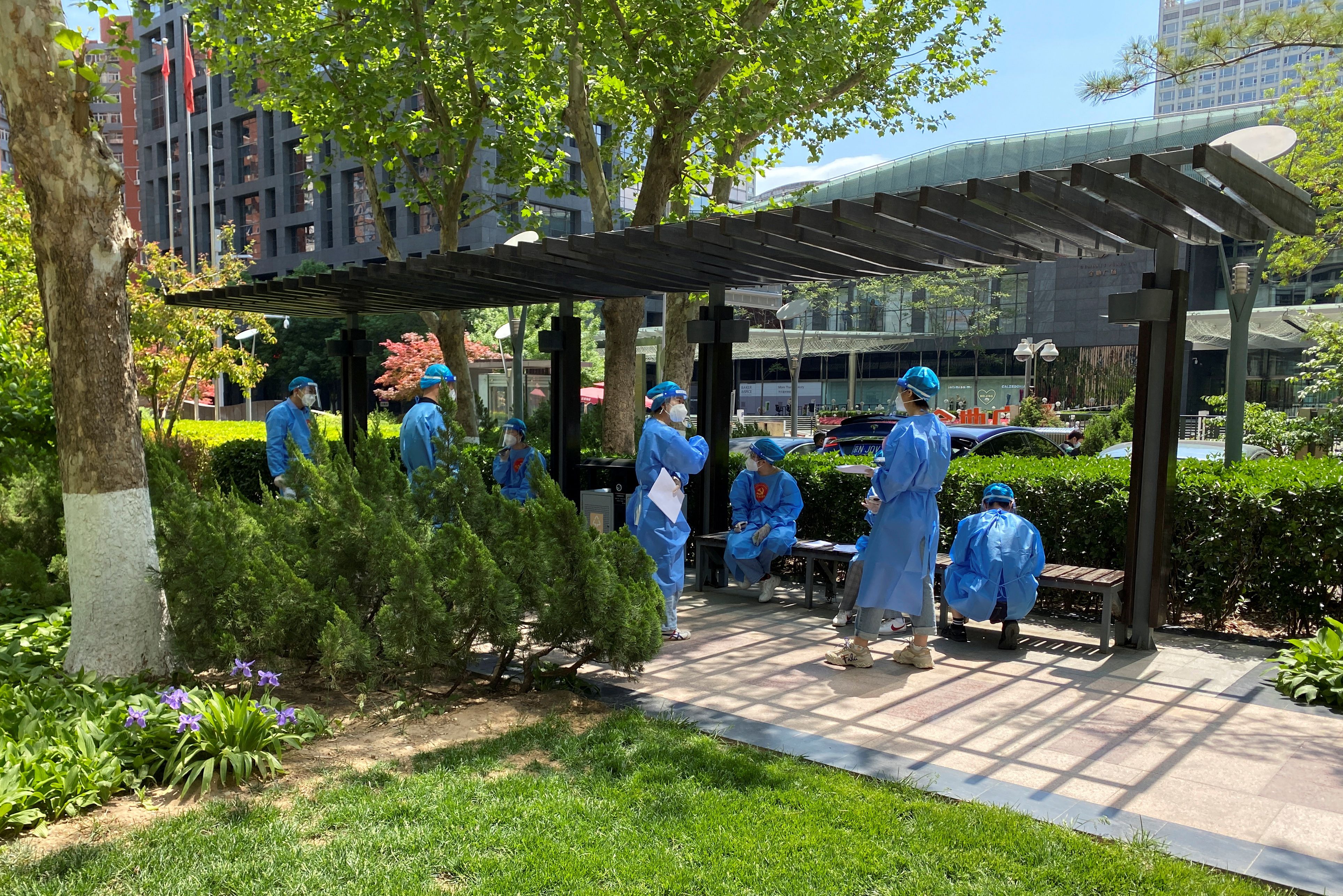 Workers in protective suits gather at a residential complex amid the coronavirus disease (COVID-19) outbreak, during the Labor Day holiday in the Chaoyang district of Beijing, China.