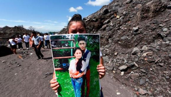 Una mujer sostiene la foto de unos familiares que murieron por la erupción del Volcán de Fuego el 3 de junio de 2018 en el primer aniversario de la tragedia en San Miguel Los Lotes, Guatemala. (Getty Images).