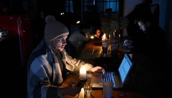 La gente descansa en una cafetería en Lviv mientras la ciudad vive un corte de energía programado el 24 de noviembre de 2022, después de los últimos ataques aéreos masivos rusos en la infraestructura energética de Ucrania.