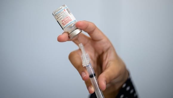 (FILES) In this file photo taken on October 14, 2021, a medical staff member prepares a syringe with a vial of the Moderna Covid-19 vaccine at a pop up vaccine clinic at the Jewish Community Centerin the Staten Island borough of New York City. - Moderna cut its 2021 forecast for Covid-19 vaccine deliveries on November 4, 2021, pushing back some doses to next year and sending shares sharply lower. The biotech company, which has soared to prominence this year on the success of its coronavirus vaccine, cited longer delivery times for international shipments. (Photo by Angela Weiss / AFP)