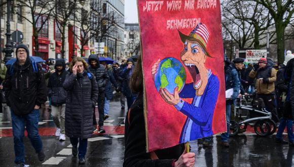 Un manifestante muestra un cartel que dice: "Ahora también probaré Europa" mientras los manifestantes asisten a la manifestación contra la guerra "Paz para Ucrania" en Berlín, el 25 de febrero de 2023. (Foto de John MACDOUGALL / AFP)