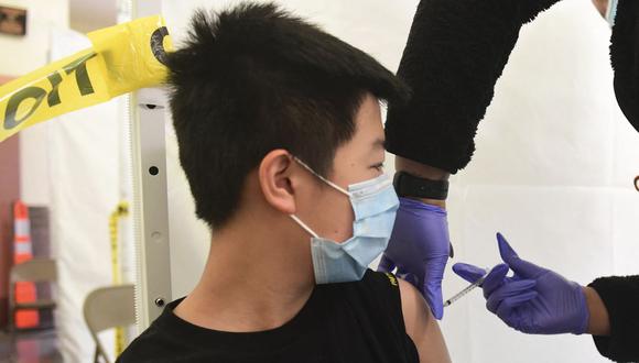 Andrew Lai, de 12 años, recibe su vacuna contra el coronavirus Covid-19 administrada por un asistente médico del St. John's Well Child & Family Center en Abraham Lincoln High School en Los Ángeles, Estados Unidos. (Foto de Frederic J. BROWN / AFP).