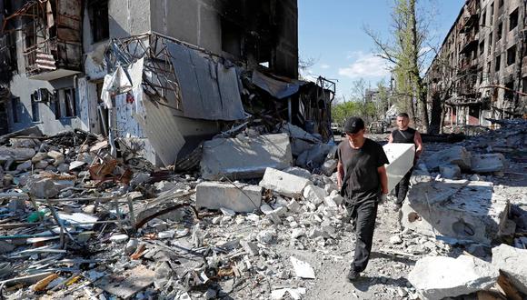 Residentes locales sacan muebles de un edificio de apartamentos gravemente dañado en la ciudad portuaria de Mariupol, Ucrania, 28 de abril de 2022. (REUTERS/Alexander Ermochenko).