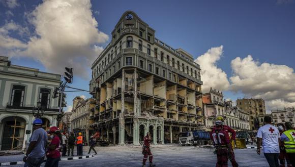 Rescatistas y miembros de la Cruz Roja Cubana caminan frente al dañado Hotel Saratoga, en La Habana Vieja, Cuba.