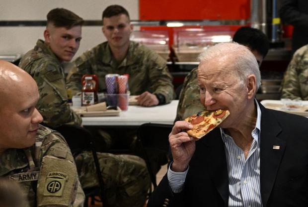 US President Joe Biden eats a pizza while meeting with servicemen from the 82nd Airborne Division in Poland.  (BRENDAN SMIALOWSKI / AFP).