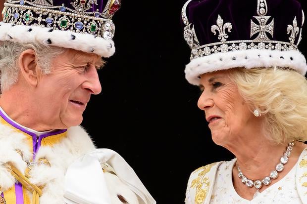 Britain's King Charles III looks at Queen Camilla as they stand on the balcony of Buckingham Palace, in London, after his coronation, on May 6, 2023. (Photo by Leon Neal / POOL / AFP)